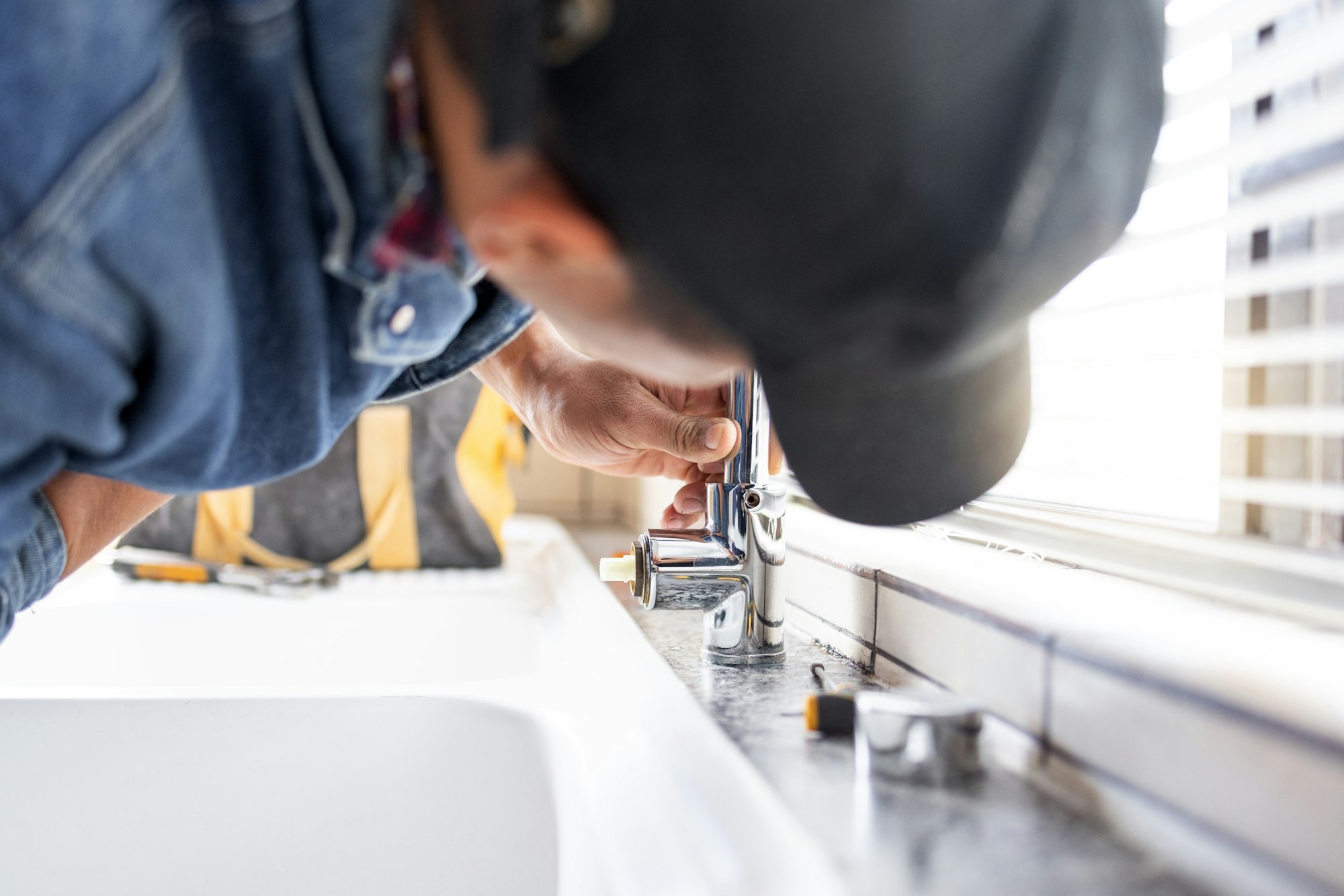 Plumber fixing faucet, plumbing and maintenance with man, manual labour and home renovation with tr Plumber fixing faucet, plumbing and maintenance with man, manual labour and home renovation with tr